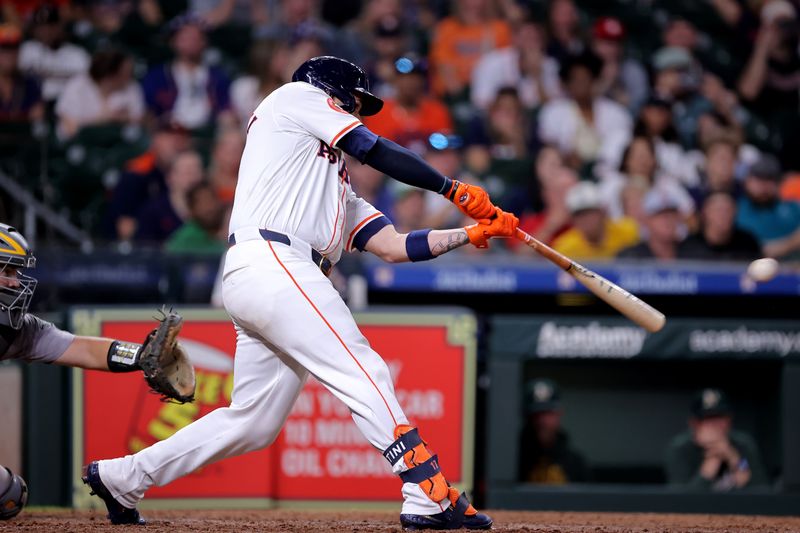 May 14, 2024; Houston, Texas, USA; Houston Astros pinch hitter Victor Caratini (17) hits a walkoff RBI single against the Oakland Athletics during the tenth inning at Minute Maid Park. Mandatory Credit: Erik Williams-USA TODAY Sports