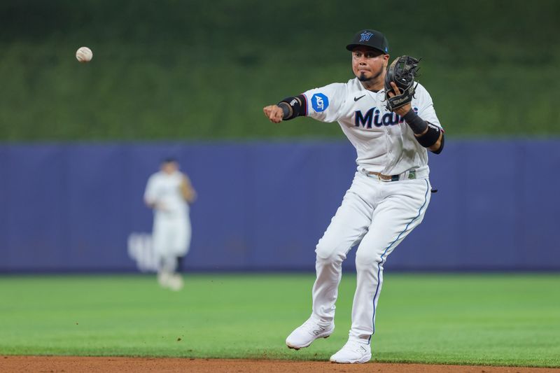 Jul 30, 2023; Miami, Florida, USA; Miami Marlins second baseman Luis Arraez (3) throws to first baseman Yuli Gurriel (not pictured) but cannot retire Detroit Tigers shortstop Javier Baez (not picuted) during the second inning at loanDepot Park. Mandatory Credit: Sam Navarro-USA TODAY Sports