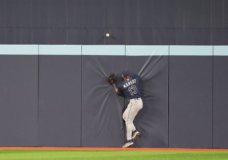 Sep 29, 2023; Toronto, Ontario, CAN; Tampa Bay Rays center fielder Manuel Margot (13) is unable to catch a ball hit by Toronto Blue Jays third baseman Matt Chapman (26) (not pictured) for a home run during the fifth inning at Rogers Centre. Mandatory Credit: Nick Turchiaro-USA TODAY Sports