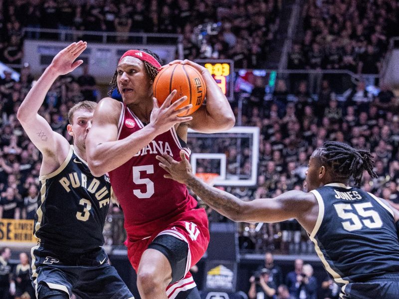 Feb 10, 2024; West Lafayette, Indiana, USA; Indiana Hoosiers forward Malik Reneau (5) dribbles the ball while Purdue Boilermakers guard Lance Jones (55) and  guard Braden Smith (3) defend in the first half at Mackey Arena. Mandatory Credit: Trevor Ruszkowski-USA TODAY Sports