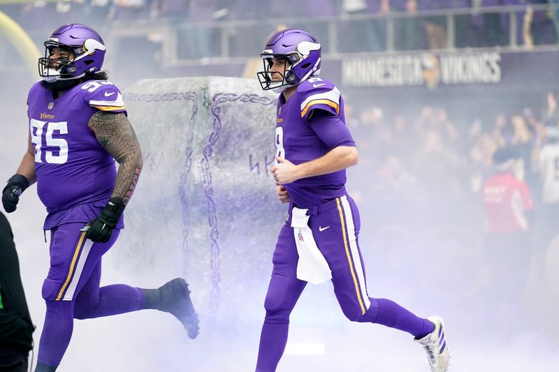 Minnesota Vikings defensive tackle Khyiris Tonga (95) and quarterback Kirk Cousins (8) run onto the field before an NFL wild card playoff football game against the New York Giants, Sunday, Jan. 15, 2023, in Minneapolis. (AP Photo/Charlie Neibergall)