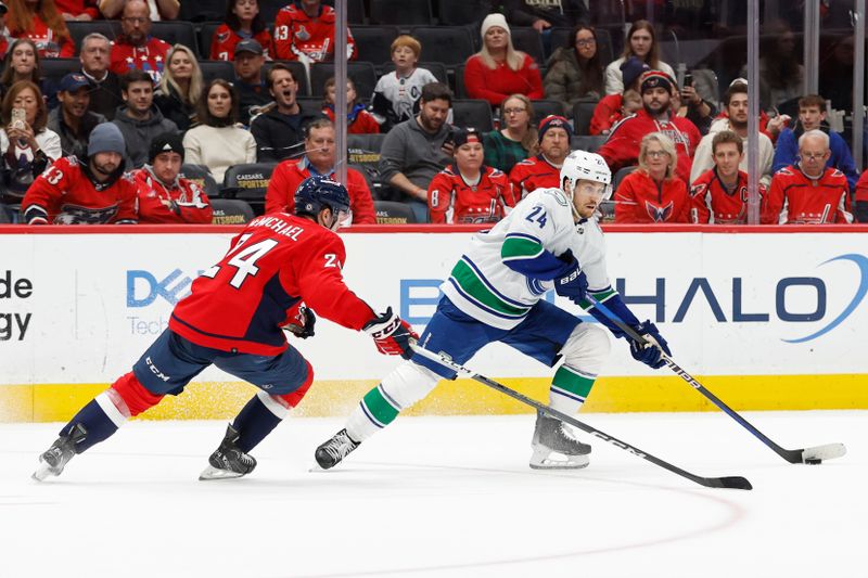 Feb 11, 2024; Washington, District of Columbia, USA; Vancouver Canucks center Pius Suter (24) skates with the puck as Washington Capitals center Connor McMichael (24) defends in overtime at Capital One Arena. Mandatory Credit: Geoff Burke-USA TODAY Sports