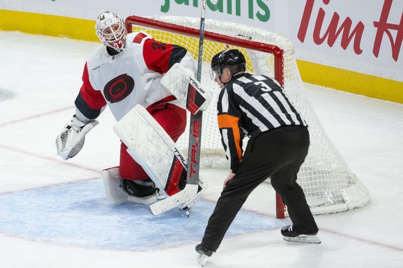 Jan 24, 2026; Ottawa, Ontario, CAN; Carolina Hurricanes goalie Brandon Bussi (32) speaks with referee Chris Schlenker (3) in the third period against the Ottawa Senators at the Canadian Tire Centre. Mandatory Credit: Marc DesRosiers-IMAGN Images