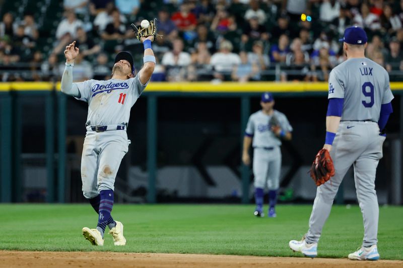Jun 25, 2024; Chicago, Illinois, USA; Los Angeles Dodgers shortstop Miguel Rojas (11) catches a fly ball hit by Chicago White Sox outfielder Luis Robert Jr. (not pictured) during the ninth inning at Guaranteed Rate Field. Mandatory Credit: Kamil Krzaczynski-USA TODAY Sports