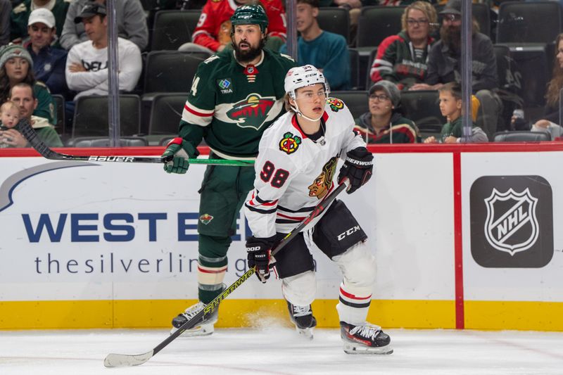 Oct 1, 2024; Saint Paul, Minnesota, USA; Chicago Blackhawks center Connor Bedard (98) escapes an encounter with Minnesota Wild defenseman Zach Bogosian (24) in the first period at Xcel Energy Center. Mandatory Credit: Matt Blewett-Imagn Images