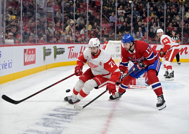 Apr 8, 2025; Montreal, Quebec, CAN; Detroit Red Wings forward Dylan Larkin (71) plays the puck and Montreal Canadiens forward Josh Anderson (17) forechecks during the second period at the Bell Centre. Mandatory Credit: Eric Bolte-Imagn Images