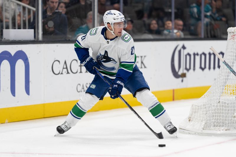 Nov 2, 2023; San Jose, California, USA; Vancouver Canucks left wing Nils Hoglander (21) controls the puck during the third period against the San Jose Sharks at SAP Center at San Jose. Mandatory Credit: Stan Szeto-USA TODAY Sports