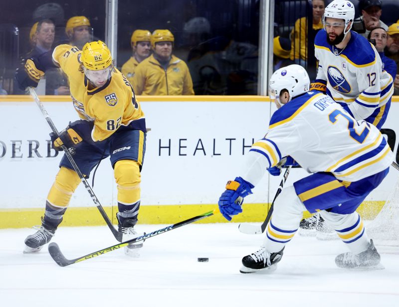 Mar 7, 2024; Nashville, Tennessee, USA; Nashville Predators center Tommy Novak (82) attempts to get the puck past Buffalo Sabres right wing Kyle Okposo (21) during their game at Bridgestone Arena. Mandatory Credit: Alan Poizner-USA TODAY Sports