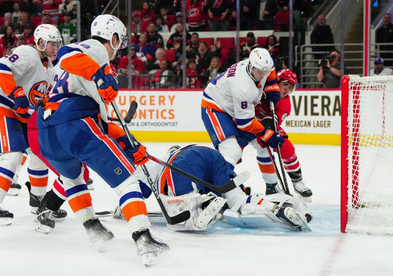 Dec 23, 2023; Raleigh, North Carolina, USA; Carolina Hurricanes left wing Teuvo Teravainen (86) scores goal past New York Islanders goaltender Ilya Sorokin (30) and defenseman Noah Dobson (8) during the first period at PNC Arena. Mandatory Credit: James Guillory-USA TODAY Sports