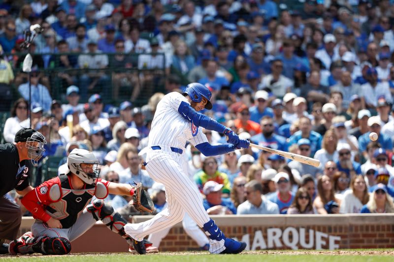 Jun 2, 2024; Chicago, Illinois, USA; Chicago Cubs outfielder Cody Bellinger (24) hits an RBI single against the Cincinnati Reds during the fifth inning at Wrigley Field. Mandatory Credit: Kamil Krzaczynski-USA TODAY Sports