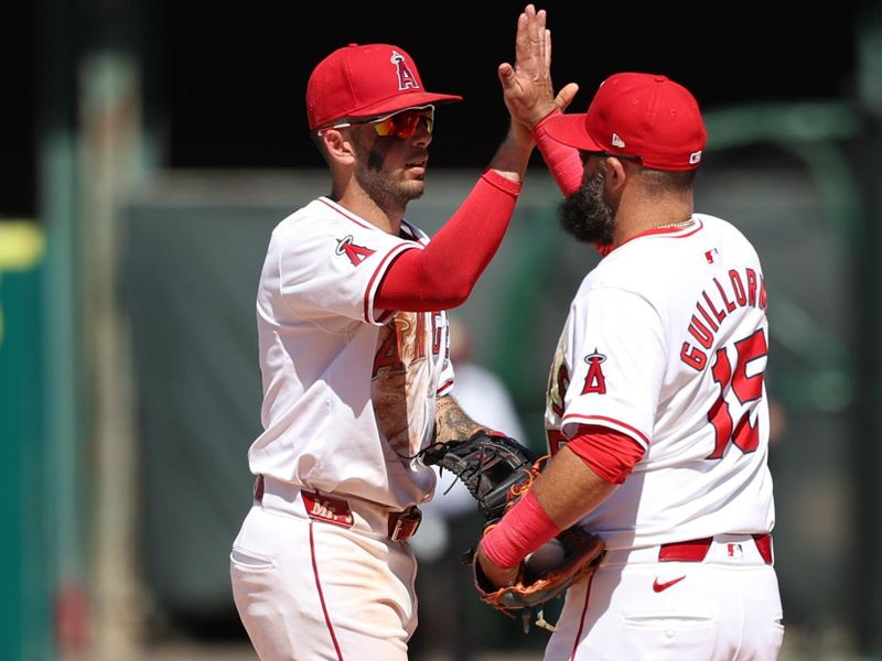 Jun 26, 2024; Anaheim, California, USA;  Los Angeles Angels shortstop Zach Neto (9) celebrates a victory with second baseman Luis Guillorme (15) after defeating the Oakland Athletics 5-2 at Angel Stadium. Mandatory Credit: Kiyoshi Mio-USA TODAY Sports