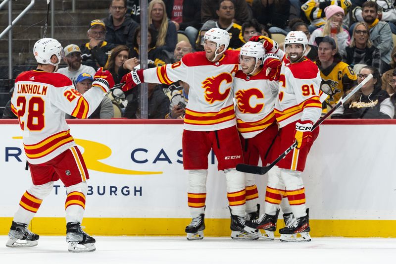 Oct 14, 2023; Pittsburgh, Pennsylvania, USA; Calgary Flames center Jonathan Huberdeau (10) and center Nazem Kadri (91) celebrate a goal by right winger Matt Coronato (27) as center Elias Lindholm (28) joins the celebration against the Pittsburgh Penguins during the second period at PPG Paints Arena. Mandatory Credit: Scott Galvin-USA TODAY Sports