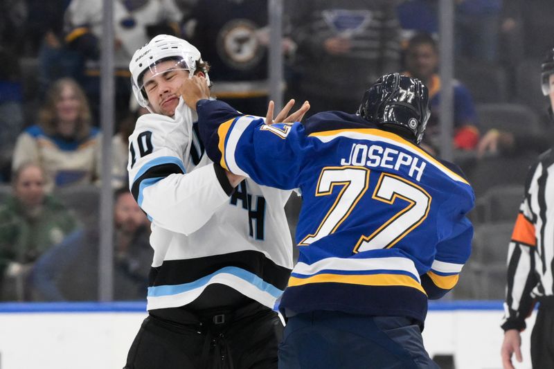 Nov 7, 2024; St. Louis, Missouri, USA; Utah Hockey Club defenseman Maveric Lamoureux (10) fights St. Louis Blues defenseman Pierre-Olivier Joseph (77) during the second period at Enterprise Center. Mandatory Credit: Jeff Le-Imagn Images