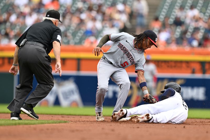 Jun 13, 2024; Detroit, Michigan, USA;  Detroit Tigers first baseman Mark Canha (21) beats the tag by Washington Nationals shortstop CJ Abrams (5) to steal second base in the first inning at Comerica Park. Mandatory Credit: Lon Horwedel-USA TODAY Sports