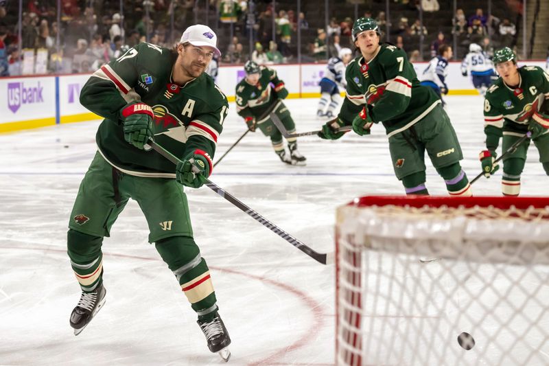 Nov 25, 2024; Saint Paul, Minnesota, USA;  Minnesota Wild forward Marcus Foligno (17) shoots a puck during warm up before a game against the Winnipeg Jets at Xcel Energy Center. Mandatory Credit: Nick Wosika-Imagn Images