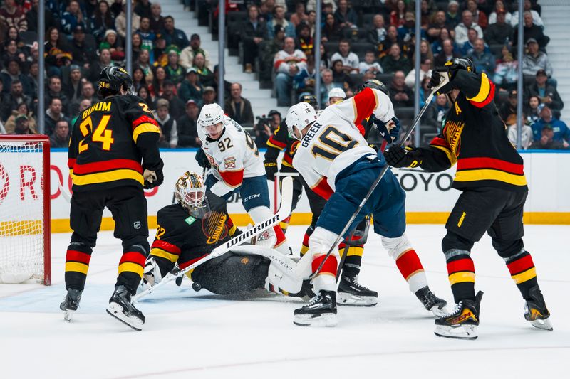 Mar 17, 2026; Vancouver, British Columbia, CAN; Florida Panthers forward Tomas Nosek (92), forward A.J. Greer (10) and Vancouver Canucks defenseman Zeev Buium (24) and defenseman Filip Hronek (17) watch as goalie Kevin Lankinen (32) makes a save in the first period at Rogers Arena. Mandatory Credit: Bob Frid-Imagn Images