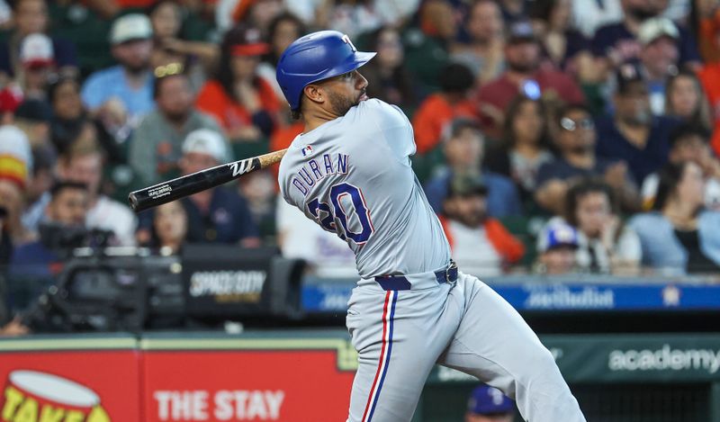 Apr 14, 2024; Houston, Texas, USA; Texas Rangers first baseman Ezequiel Duran (20) hits a single during the seventh inning against the Houston Astros at Minute Maid Park. Mandatory Credit: Troy Taormina-USA TODAY Sports