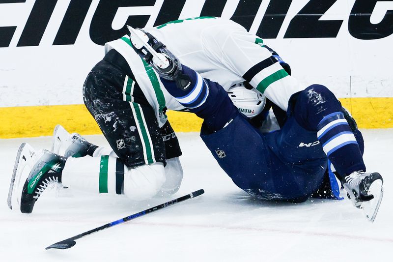 May 7, 2025; Winnipeg, Manitoba, CAN; Winnipeg Jets defenseman Dylan DeMelo (2) engages Dallas Stars forward Roope Hintz (24) during the third period in game one of the second round of the 2025 Stanley Cup Playoffs at Canada Life Centre. Mandatory Credit: Terrence Lee-Imagn Images