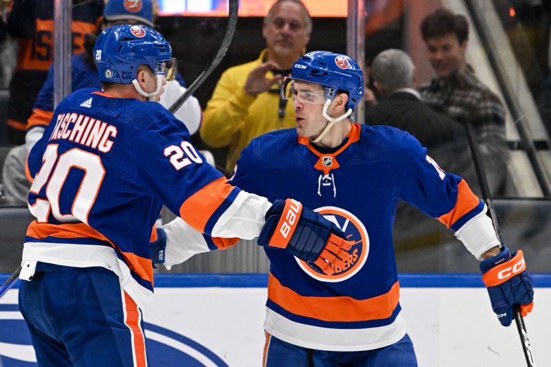 Mar 23, 2024; Elmont, New York, USA;  New York Islanders right wing Hudson Fasching (20) celebrates his goal against the Winnipeg Jets with New York Islanders center Mathew Barzal (13) during the second period at UBS Arena. Mandatory Credit: Dennis Schneidler-USA TODAY Sports