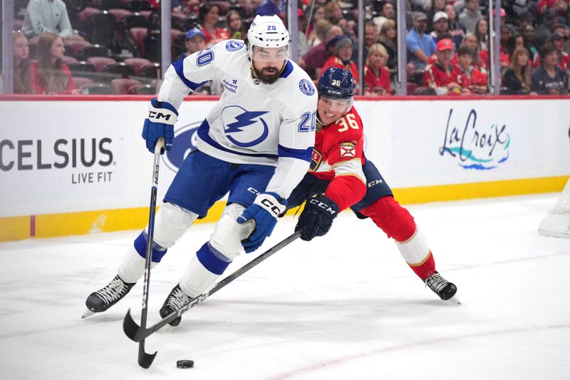 Sep 30, 2024; Sunrise, Florida, USA; Tampa Bay Lightning left wing Nicholas Paul (20) and Florida Panthers right wing Patrick Giles (36) battle for possession during the first period at Amerant Bank Arena. Mandatory Credit: Jim Rassol-Imagn Images