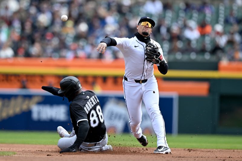 Apr 6, 2025; Detroit, Michigan, USA;  Detroit Tigers shortstop Javier Báez (28) attempts to turn a double play as Chicago White Sox center fielder Luis Robert Jr. (88) slides into second base in the first inning at Comerica Park. Mandatory Credit: Lon Horwedel-Imagn Images