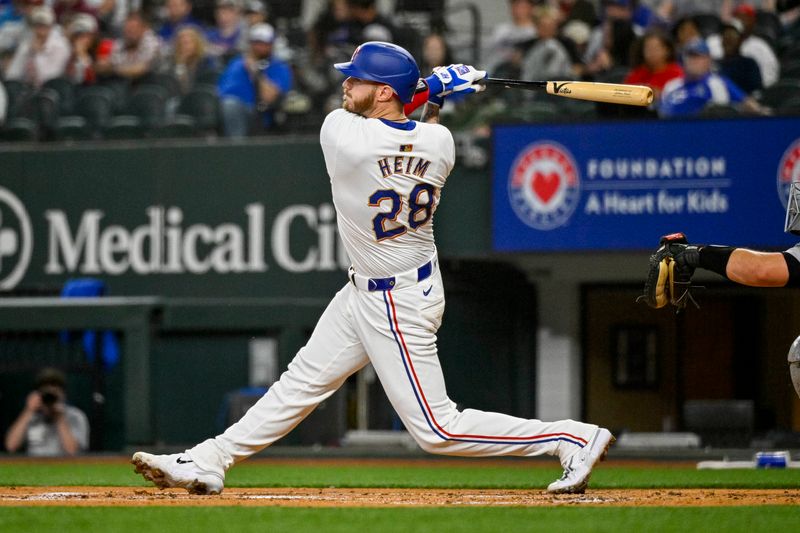 Apr 10, 2024; Arlington, Texas, USA; Texas Rangers catcher Jonah Heim (28) hits a single and drives in two runs against the Oakland Athletics during the first inning at Globe Life Field. Mandatory Credit: Jerome Miron-USA TODAY Sports