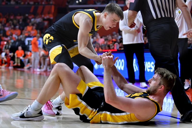 Feb 24, 2024; Champaign, Illinois, USA;  Iowa Hawkeyes guard Brock Harding (2) lends a hand to teammate  Ben Krikke (23) during the second half against the Illinois Fighting Illini at State Farm Center. Mandatory Credit: Ron Johnson-USA TODAY Sports