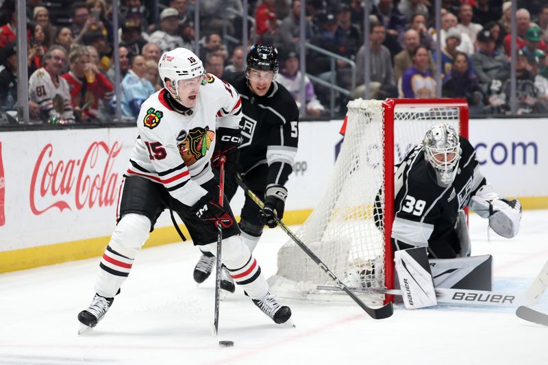 Mar 19, 2024; Los Angeles, California, USA;  Chicago Blackhawks right wing Joey Anderson (15) controls the puck in front of Los Angeles Kings defenseman Andreas Englund (5) during the second period at Crypto.com Arena. Mandatory Credit: Kiyoshi Mio-USA TODAY Sports