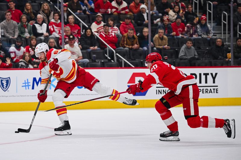 Nov 27, 2024; Detroit, Michigan, USA; Calgary Flames defenseman Daniil Miromanov (62) shoots as Detroit Red Wings defenseman Albert Johansson (20) defends during the first period at Little Caesars Arena. Mandatory Credit: Tim Fuller-Imagn Images