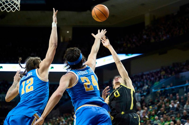 Feb 11, 2023; Eugene, Oregon, USA; Oregon Ducks guard Will Richardson (0) shoots a basket during the first half against UCLA Bruins forward Mac Etienne (12) and guard Jaime Jaquez Jr. (24) at Matthew Knight Arena. Mandatory Credit: Troy Wayrynen-USA TODAY Sports