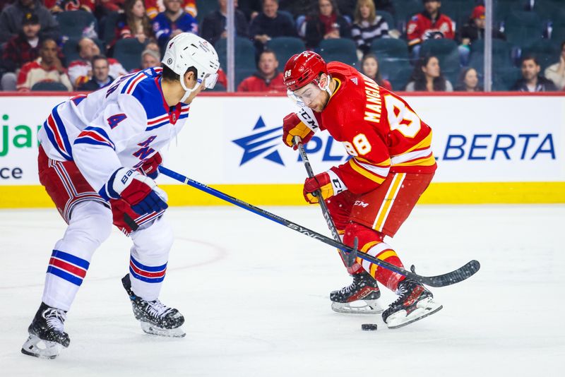 Oct 24, 2023; Calgary, Alberta, CAN; Calgary Flames left wing Andrew Mangiapane (88) and New York Rangers defenseman Braden Schneider (4) battle for the puck during the second period at Scotiabank Saddledome. Mandatory Credit: Sergei Belski-USA TODAY Sports