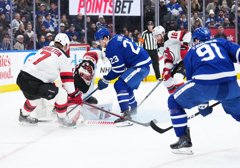 Dec 30, 2025; Toronto, Ontario, CAN; Toronto Maple Leafs left wing Matthew Knies (23) battles for the puck with New Jersey Devils defenseman Dougie Hamilton (7) during the first period at Scotiabank Arena. Mandatory Credit: Nick Turchiaro-Imagn Images