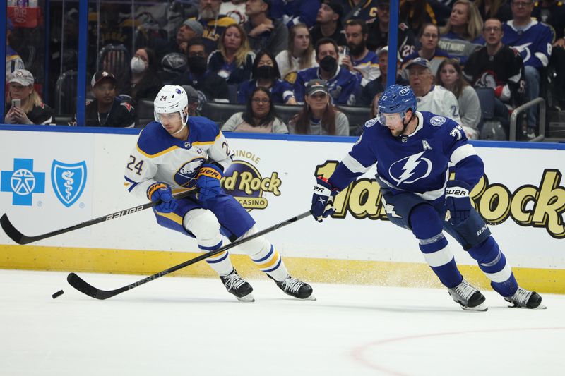 Feb 29, 2024; Tampa, Florida, USA;  Tampa Bay Lightning defenseman Victor Hedman (77) and Buffalo Sabres center Dylan Cozens (24) fight for the puck in the second period at Amalie Arena. Mandatory Credit: Nathan Ray Seebeck-USA TODAY Sports