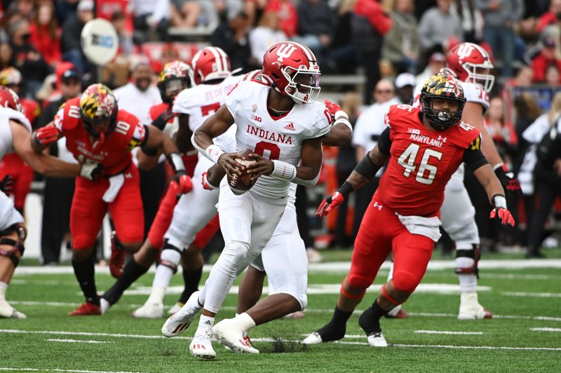 Oct 30, 2021; College Park, Maryland, USA;  Indiana Hoosiers quarterback Donaven McCulley (0) rolls out to throw during the second half as Maryland Terrapins defensive lineman Greg Rose (46) defends at Capital One Field at Maryland Stadium. Mandatory Credit: Tommy Gilligan-USA TODAY Sports