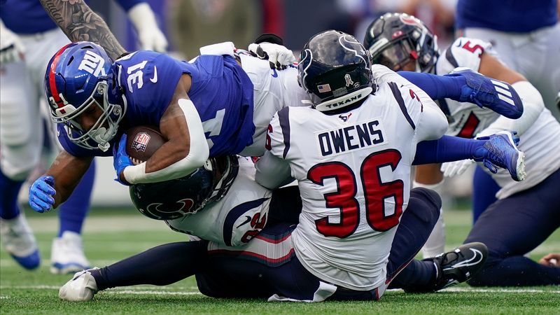 New York Giants running back Matt Breida (31) is tackled by Houston Texans safety Jonathan Owens (36) during the second quarter of an NFL football game, Sunday, Nov. 13, 2022, in East Rutherford, N.J. (AP Photo/John Minchillo)