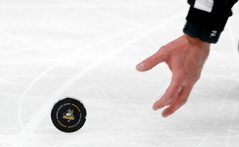 Mar 16, 2024; Pittsburgh, Pennsylvania, USA;  An NHL official reaches for a puck on the ice during the first period between the New York Rangers and the Pittsburgh Penguins at PPG Paints Arena. New York won 7-4.  Mandatory Credit: Charles LeClaire-USA TODAY Sports