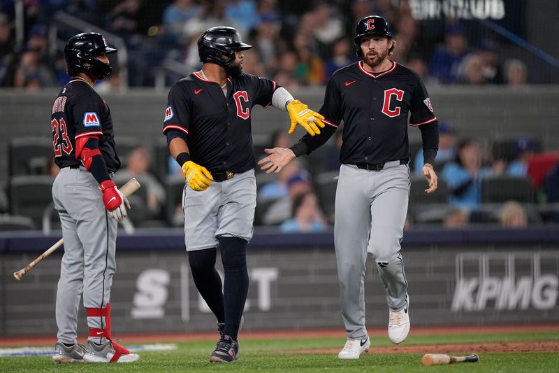 May 4, 2025; Toronto, Ontario, CAN; Cleveland Guardians designated hitter Carlos Santana (left) and second baseman Daniel Schneemann (right)  celebrate scoring against the Toronto Blue Jays on a single by Cleveland Guardians shortstop Gabriel Arias (not pictured) during the fourth inning at Rogers Centre. Mandatory Credit: John E. Sokolowski-Imagn Images