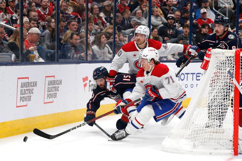 Nov 27, 2024; Columbus, Ohio, USA; Columbus Blue Jackets defenseman Dante Fabbro (15) falls to the ice as he battles for the puck with Montreal Canadiens center Jake Evans (71) during the third period at Nationwide Arena. Mandatory Credit: Russell LaBounty-Imagn Images