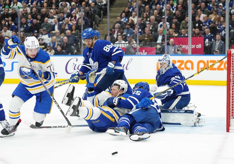 Mar 6, 2024; Toronto, Ontario, CAN; Buffalo Sabres right wing JJ Peterka (77) battles for the puck with Toronto Maple Leafs right wing William Nylander (88) during the second period at Scotiabank Arena. Mandatory Credit: Nick Turchiaro-USA TODAY Sports