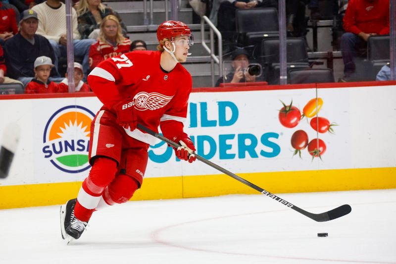 Nov 2, 2024; Detroit, Michigan, USA; Detroit Red Wings defenseman Simon Edvinsson (77) handles the puck during the first period of the game against the Buffalo Sabres at Little Caesars Arena. Mandatory Credit: Brian Bradshaw Sevald-Imagn Images