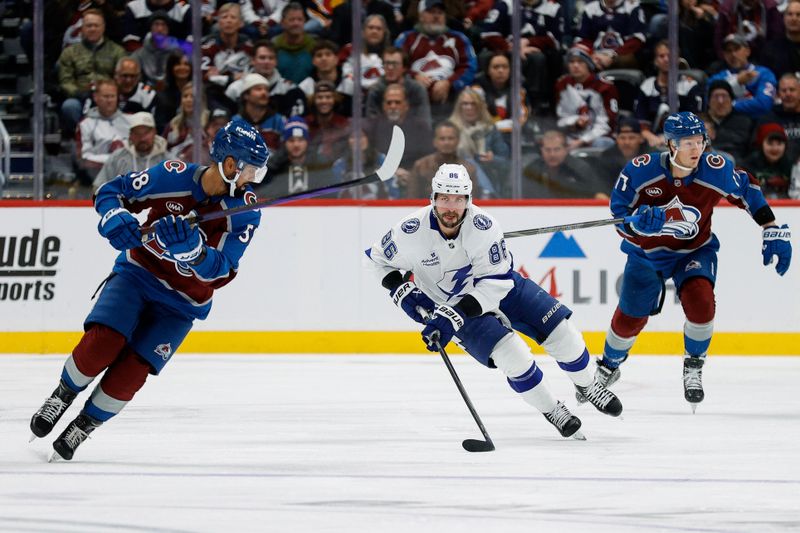 Oct 30, 2024; Denver, Colorado, USA; Tampa Bay Lightning right wing Nikita Kucherov (86) controls the puck as he skates up ice against Colorado Avalanche defenseman Oliver Kylington (58) in the first period at Ball Arena. Mandatory Credit: Isaiah J. Downing-Imagn Images