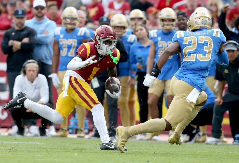 Nov 18, 2023; Los Angeles, California, USA; USC Trojans wide receiver Zachariah Branch (1) runs against UCLA Bruins defensive back Kenny Churchwell III (23) during the first quarter at United Airlines Field at Los Angeles Memorial Coliseum. Mandatory Credit: Jason Parkhurst-USA TODAY Sports