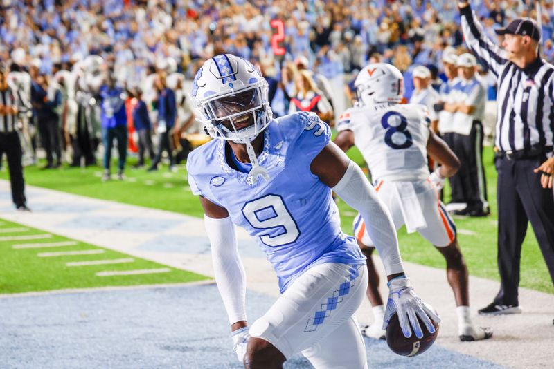 Oct 21, 2023; Chapel Hill, North Carolina, USA; North Carolina Tar Heels defensive back Armani Chatman (9) celebrates after intercepting a Virginia Cavaliers pass in the end zone in the first half at Kenan Memorial Stadium. Mandatory Credit: Nell Redmond-USA TODAY Sports