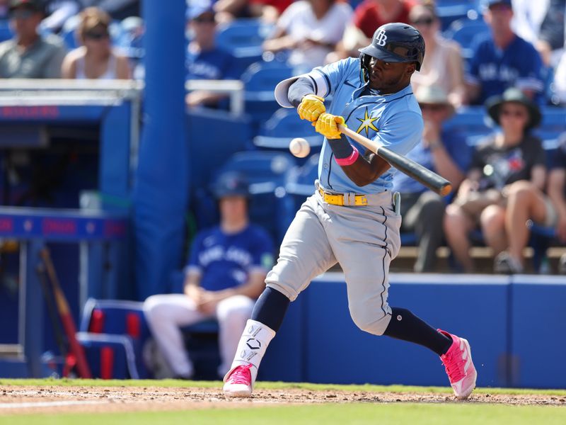 Feb 28, 2024; Dunedin, Florida, USA;  Tampa Bay Rays second baseman Ronny Simon (70) hits a sacrifice fly that scores a run against the Toronto Blue Jays in the fifth inning at TD Ballpark. Mandatory Credit: Nathan Ray Seebeck-USA TODAY Sports