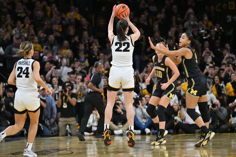 Feb 15, 2024; Iowa City, Iowa, USA; Iowa Hawkeyes guard Caitlin Clark (22) hits a three point basket to break the NCAA women's all-time scoring record as Michigan Wolverines guard Laila Phelia (5) defends at Carver-Hawkeye Arena. Mandatory Credit: Jeffrey Becker-USA TODAY Sports