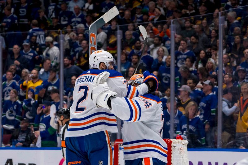 May 20, 2024; Vancouver, British Columbia, CAN; Edmonton Oilers defenseman Evan Bouchard (2) and goalie Stuart Skinner (74) celebrate their victory over the Vancouver Canucks in game seven of the second round of the 2024 Stanley Cup Playoffs at Rogers Arena. Mandatory Credit: Bob Frid-USA TODAY Sports