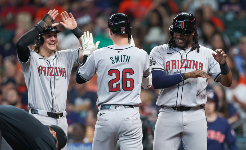 Sep 8, 2024; Houston, Texas, USA; Arizona Diamondbacks left fielder Pavin Smith (26) celebrates with center fielder Jake McCarthy (31) and first baseman Josh Bell (36) after hitting a home run during the third inning against the Houston Astros at Minute Maid Park. Mandatory Credit: Troy Taormina-Imagn Images