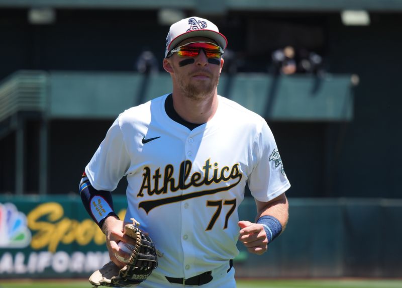 Jul 4, 2024; Oakland, California, USA; Oakland Athletics third baseman Brett Harris (77) jogs to the dugout before the game against the Los Angeles Angels at Oakland-Alameda County Coliseum. Mandatory Credit: Kelley L Cox-USA TODAY Sports