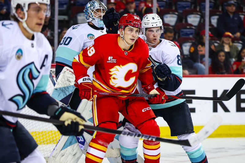 Sep 23, 2025; Calgary, Alberta, CAN; Calgary Flames left wing Samuel Honzek (29) and Seattle Kraken defenseman Cale Fleury (8) fights for position in front of Seattle Kraken goaltender Philipp Grubauer (31) during the second period at Scotiabank Saddledome. Mandatory Credit: Sergei Belski-Imagn Images