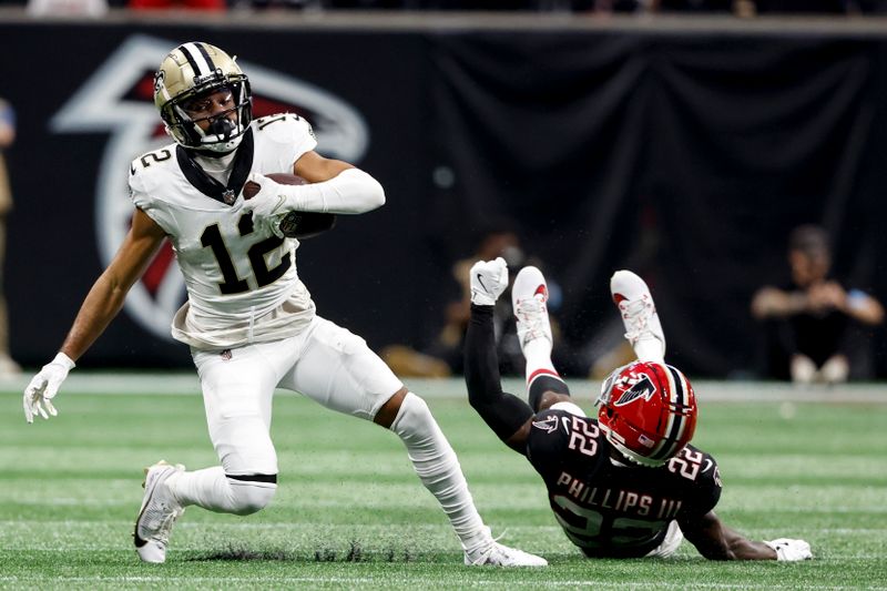 New Orleans Saints wide receiver Chris Olave (12) makes the catch against Atlanta Falcons cornerback Clark Phillips III (22) during the second half of an NFL football game, Sunday, Sept. 29, 2024, in Atlanta. (AP Photo/Butch Dill)